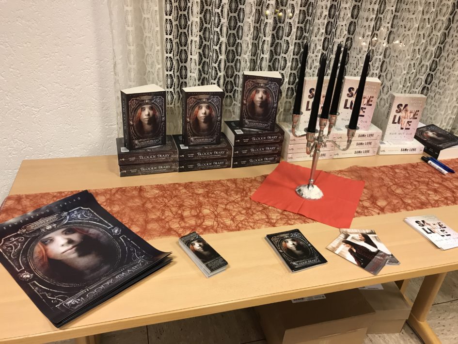 Tisch mit ausgestellten Büchern, Postern und Buchzeichen